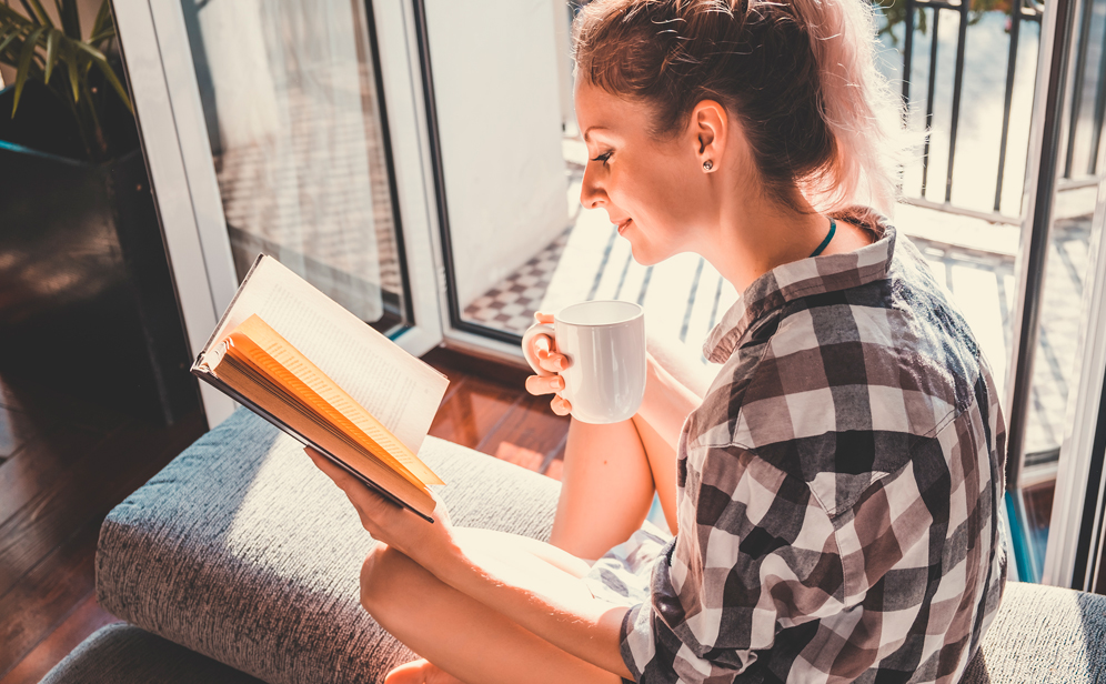 mujer leyendo mientras ventila la habitación