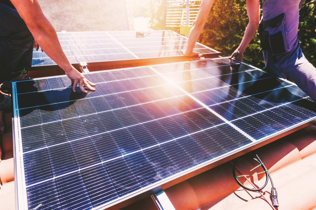 Hombres sujetando paneles solares