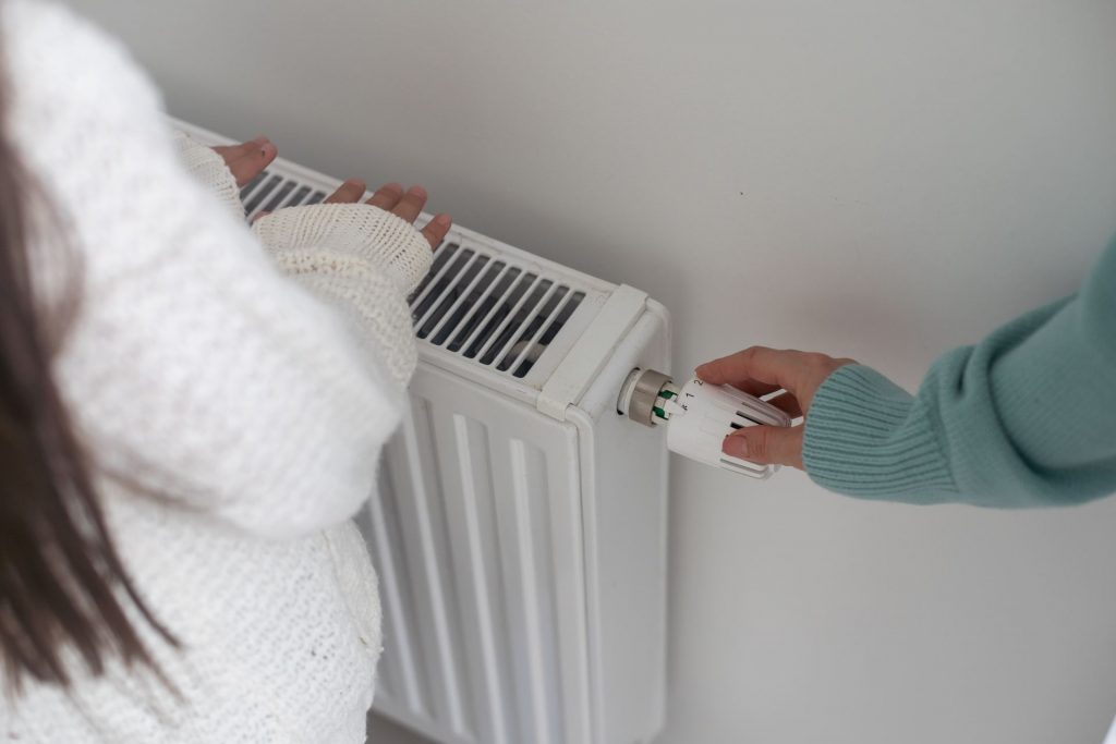Persona regulando el radiador para el ahorro energético en el hogar