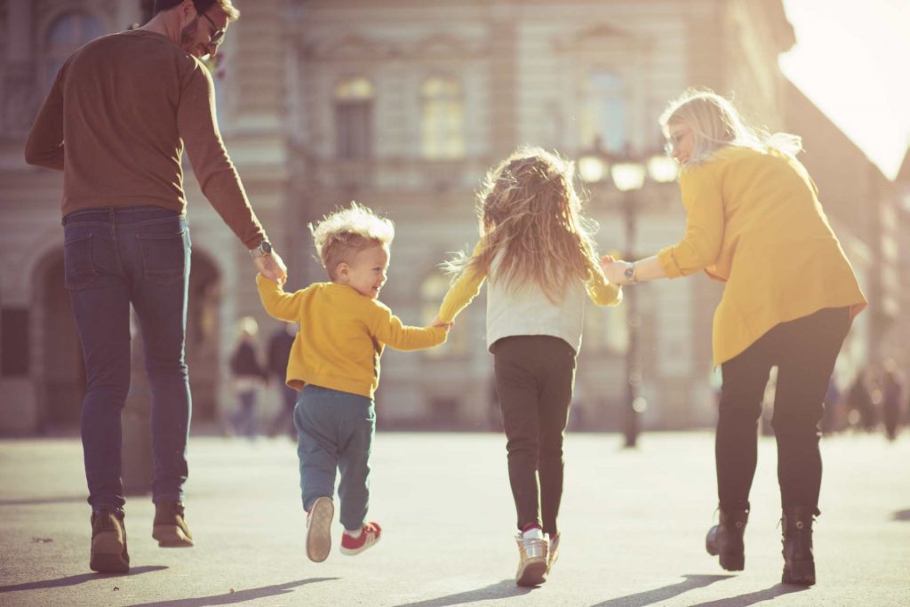 Familia paseando por la calle agarrados de la mano