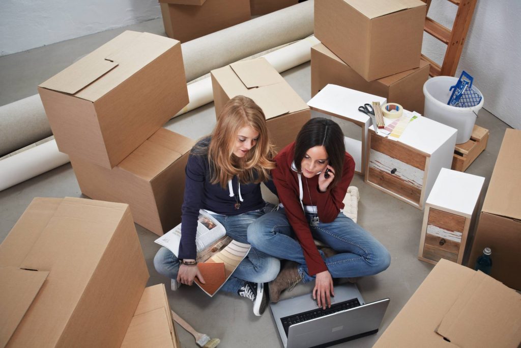 Dos chicas organizando una mudanza