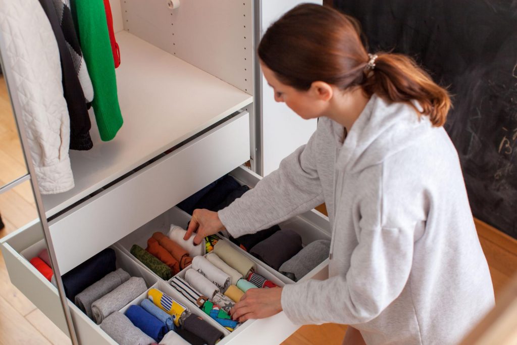 Chica ordenando el armario con metodo de organización marie kondo