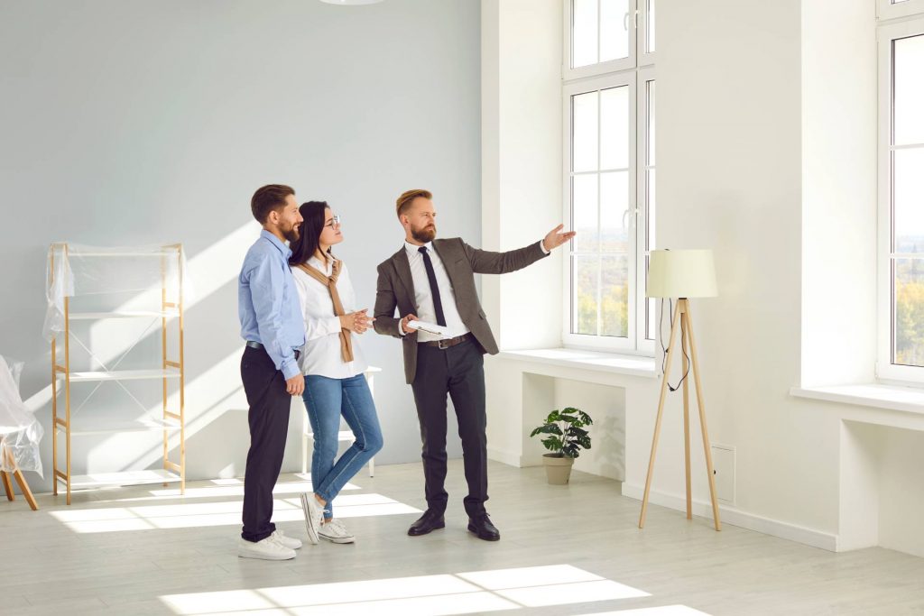 Promotor enseñando una casa a una pareja