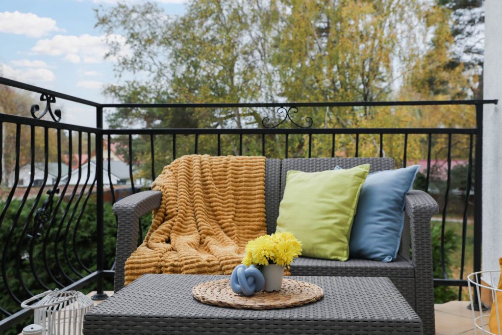 Balcón pequeño decorado con un sofá con cojines