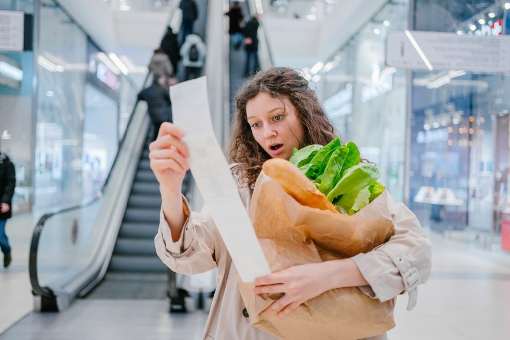 Chica mirando el ticket de la compra debido a la inflación de 2022