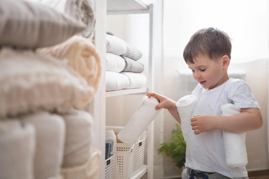 Niño ordenando toallas