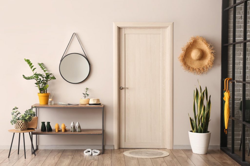 Perchero de mesa de consola y espejo en la pared beige en el pasillo diseño  de interiores