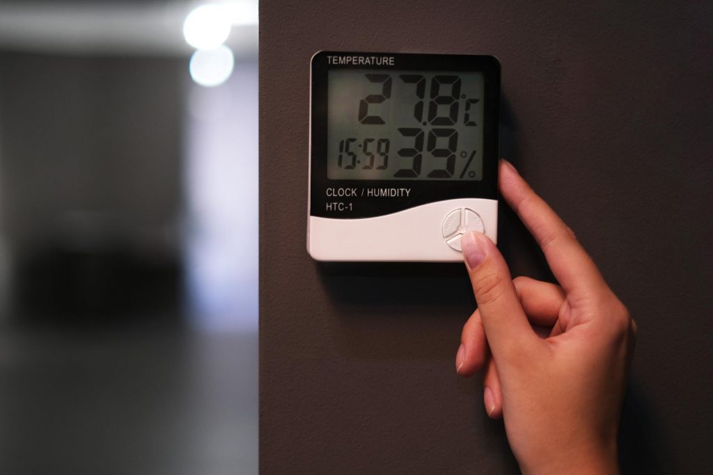 Chica controlando la temperatura del hogar