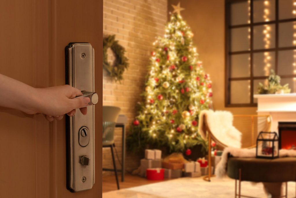 Persona abriendo la puerta a un salón con una decoración navideña