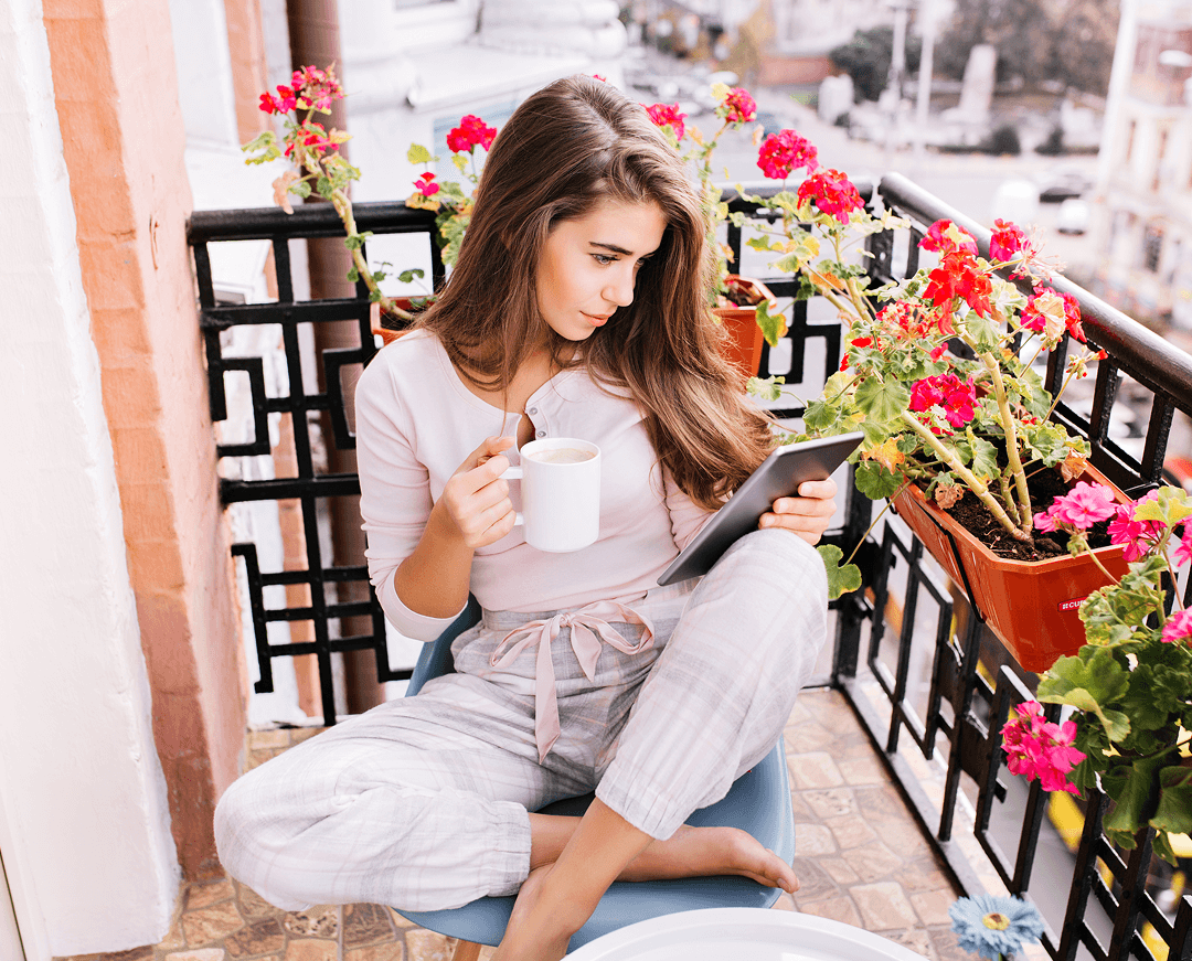 view from pretty girl pajama having breakfast balcony morning city she holds cup reading tablet 1