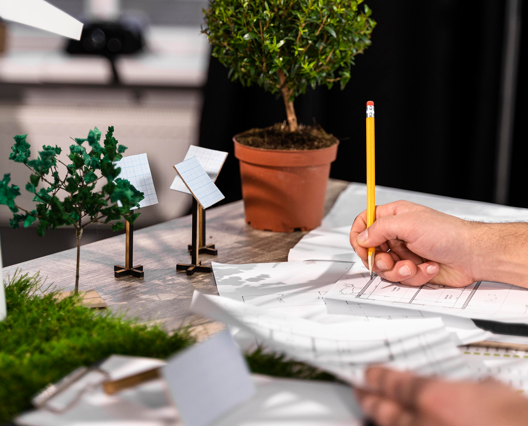 vista lateral del hombre que trabaja en un proyecto de energia eolica ecologica con planes en papel