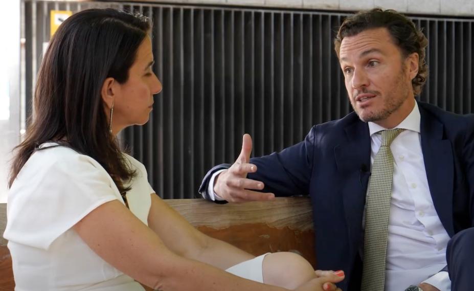 Conversación entre dos profesionales durante una entrevista en entorno corporativo