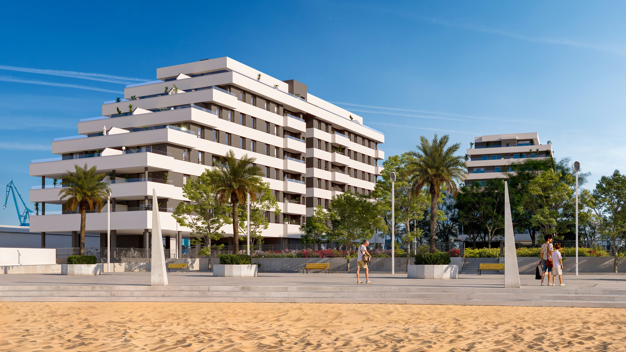 Edificios modernos con amplias terrazas frente a un paseo marítimo con palmeras y arena de playa